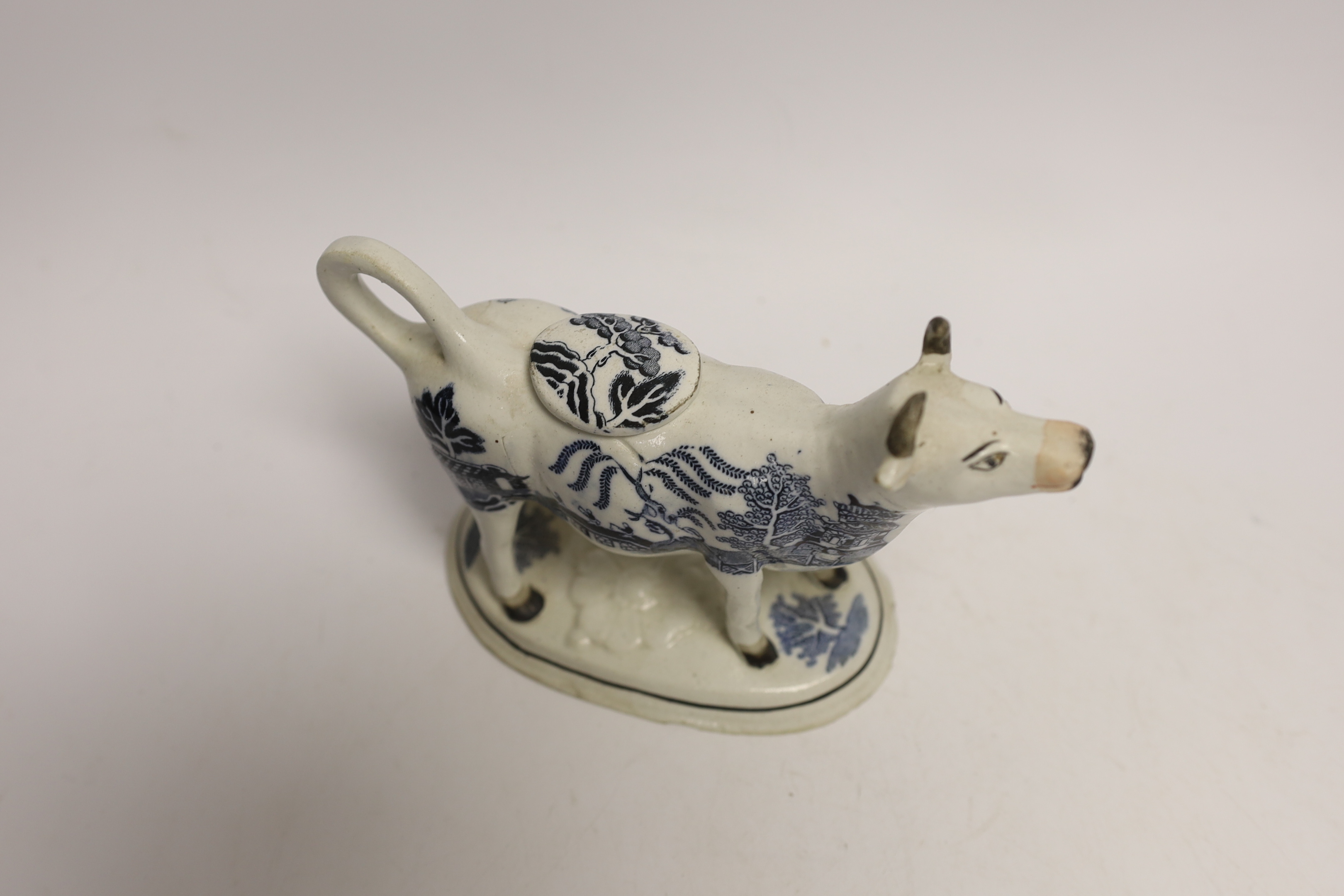 A 19th century Staffordshire porcellaneous willow pattern cow creamer, 18cm wide